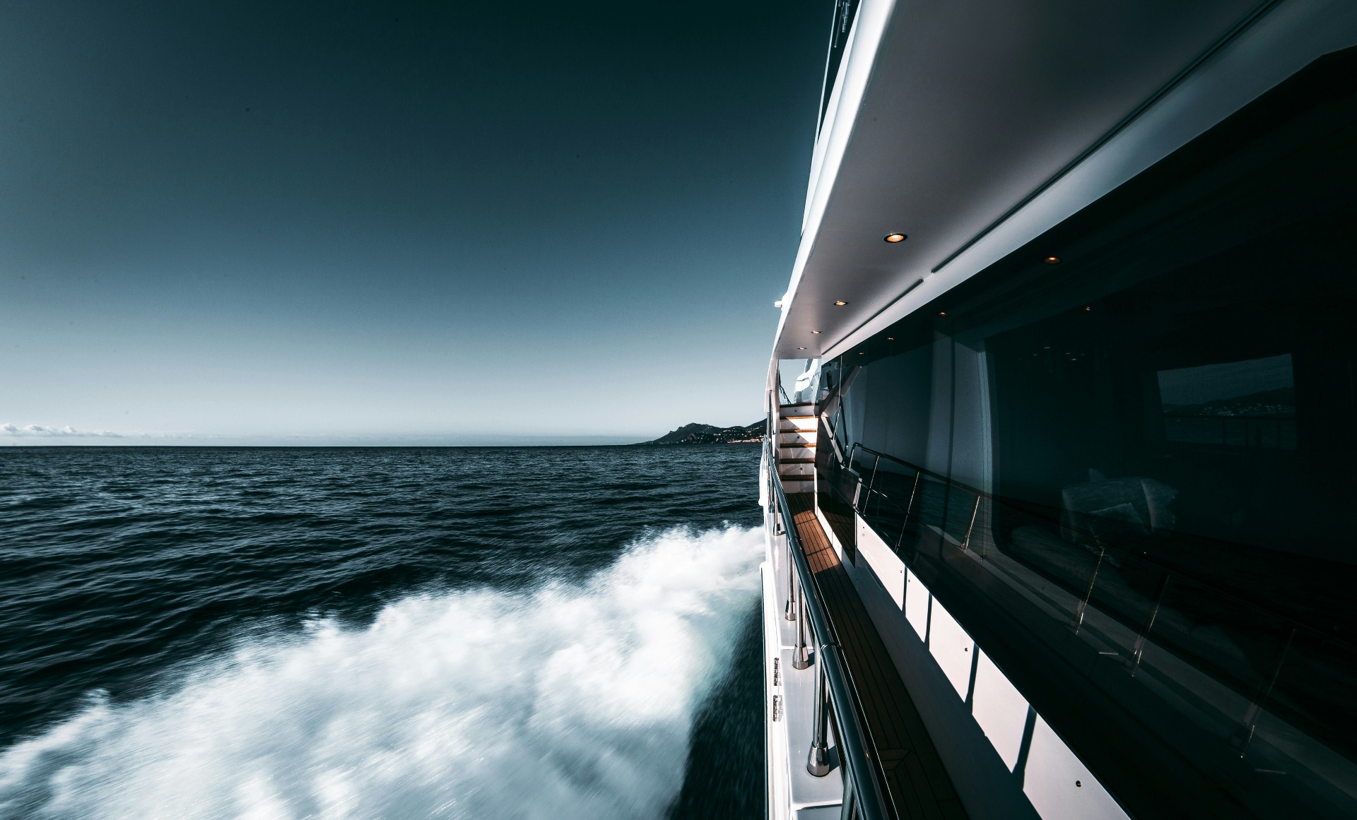 Luxury yacht cutting through dark blue sea
